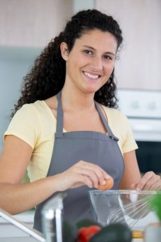 a beautiful young woman cooking in kitchen