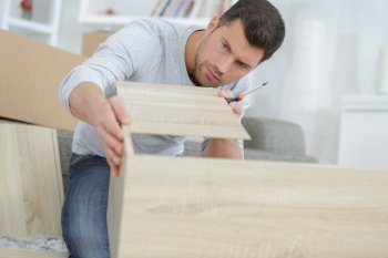 man assembling shelf at home