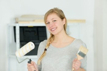 a happy woman painting a wall