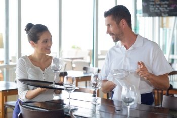 waiter and waitress interacting with each other at counter