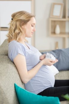 small baby shoes in the belly of pregnant woman
