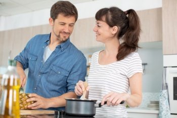 a couple is cooking in the kitchen together