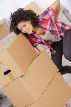 woman carrying multiple boxes causing back pain