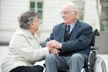 couple in wheelchair talking together visiting the city