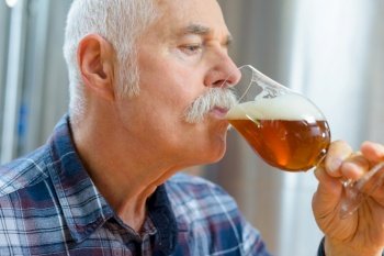 senior man drinking beer from a glass