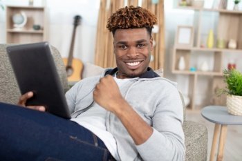 a smiling man working with tablet pc at home