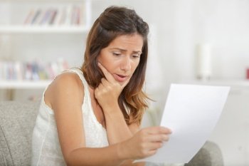 worried woman reading bad news in a letter