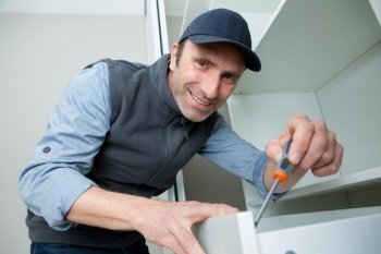 handyman installing fitted cabinet drawer