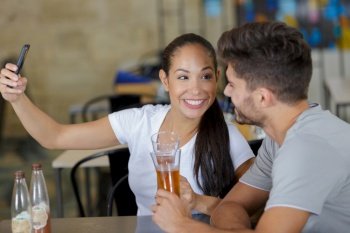 young couple taking selfie in bar