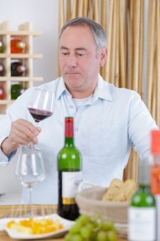 man tasting red wine in a tavern