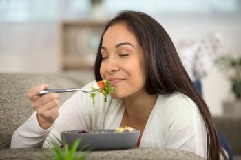positive smiling woman eating salad