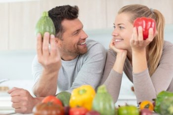 couple at home hold summer vegetables