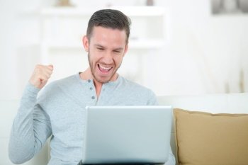 happy man smiling in front of laptop
