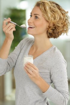 pretty woman eating natural yogurt