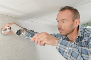 a man is installing cctv