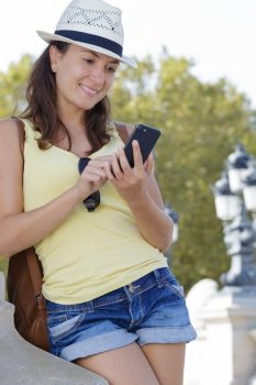 woman sending message with phone outdoors in the summer