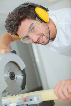 Portrait of man using circular saw