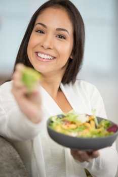 gorgeous brunette woman offering salad to the camera
