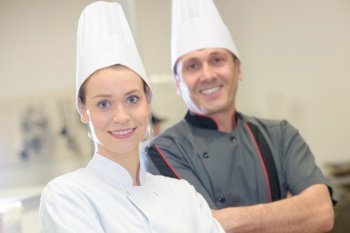chef instructing trainee in restaurant kitchen
