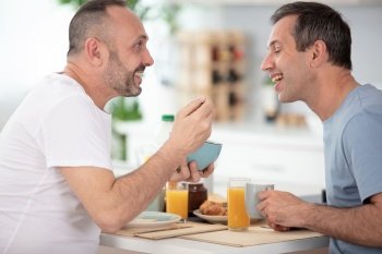 male homosexual couple are having breakfast at home