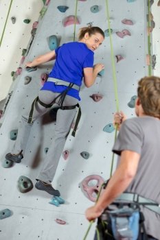 woman climbing on a wall in an climbing center