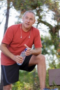 handsome tired middle aged man in sportsa bottle of water