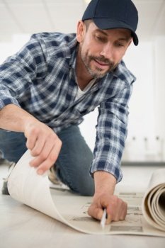 man is cutting linoleum flooring