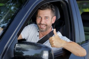 male driver making thumbs-up gesture