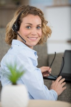 woman wearing headset and holding eyeglasses