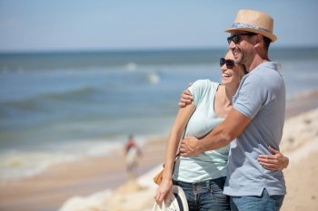 happy couple hugging and laughing together at the beach