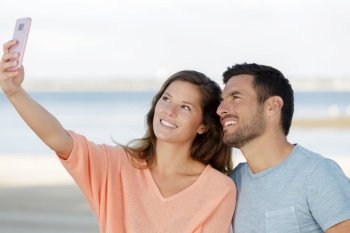 couple taking picture on the beach
