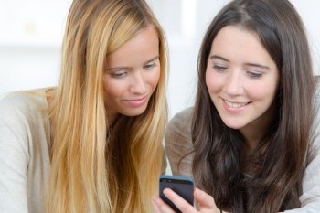 two happy teenage girls sharing technology information