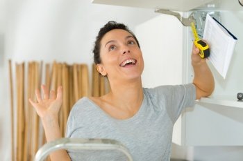 woman building shelf in her kitchen