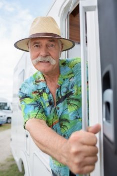 senior man riding vintage camper van