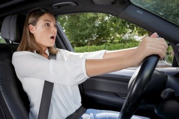 shocked woman while steering her car