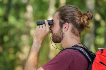 man with binoculars in the forest