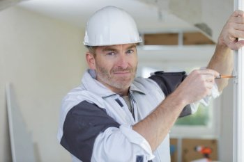portrait of builder during installation of window
