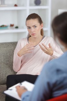 female psychologist making notes during psychological therapy