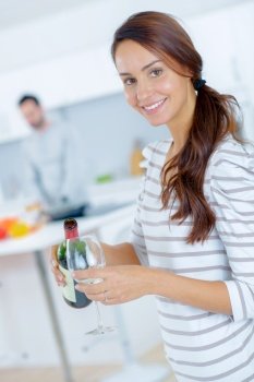 Woman pouring herself a glass of red wine