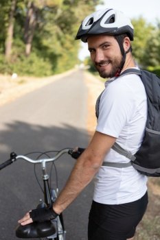 handsome young man biking in the countryside