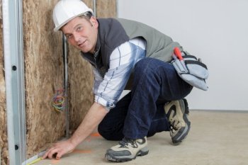 builder measuring length of a wall