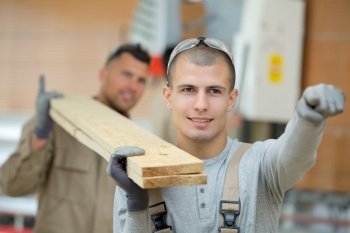 man as builder carrying wood and working