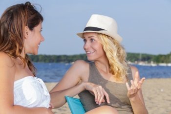 two beautiful female friends talking on beach