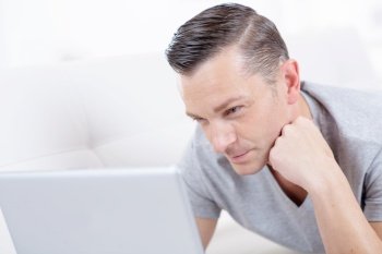 man with laptop surfing the web at home