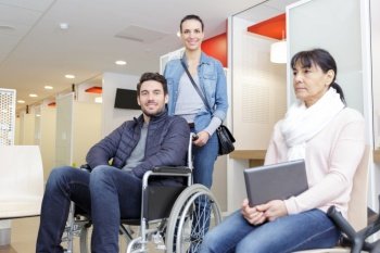 men on wheelchair in clinic lobby with his wife