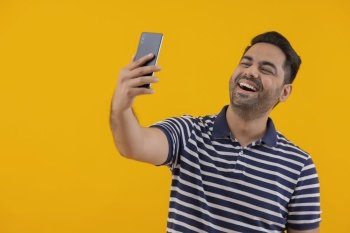 Portrait of happy young man taking selfie by using Smartphone