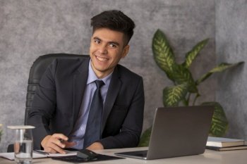 Young businessman working on laptop at his desk in office