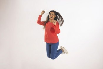 Portrait of a happy woman jumping against white background