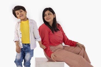 Portrait of smiling mother and son against white background