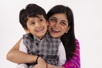 Portrait of smiling mother and son together against white background
